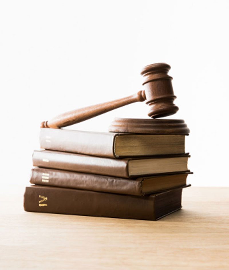 port-10 A wooden gavel resting on a stack of legal books on a desk.